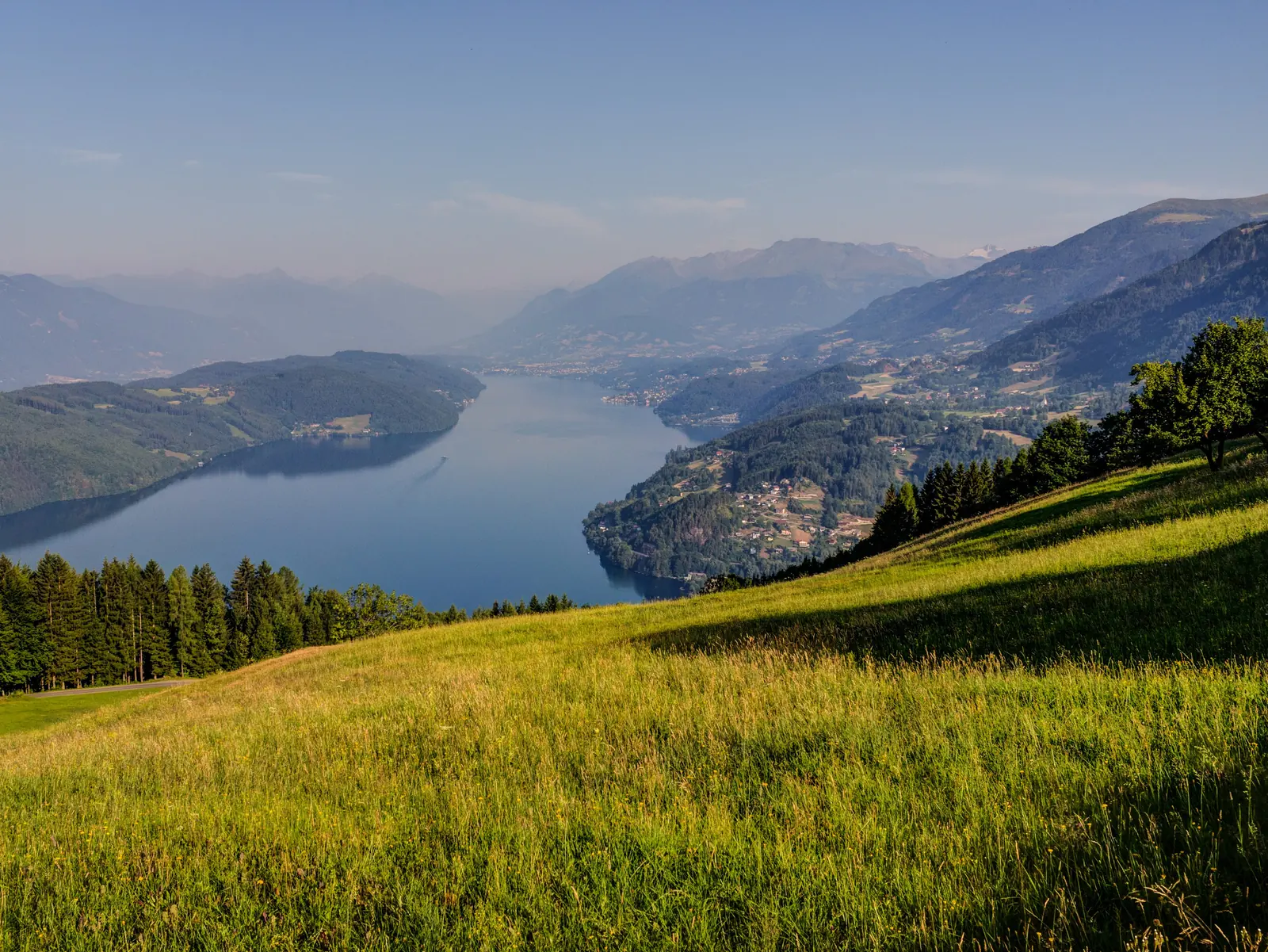 Millstätter See von Osten, Wiese im Vordergrund und Berge am Ufer